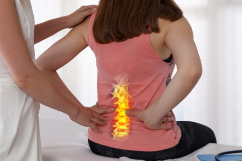 Woman treating her back pain