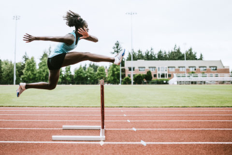 Woman Athlete Runs Hurdles for Track and Field