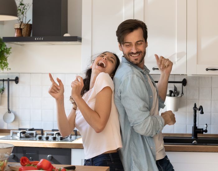Couple dancing in the kitchen while preparing to make dinner in Maryland