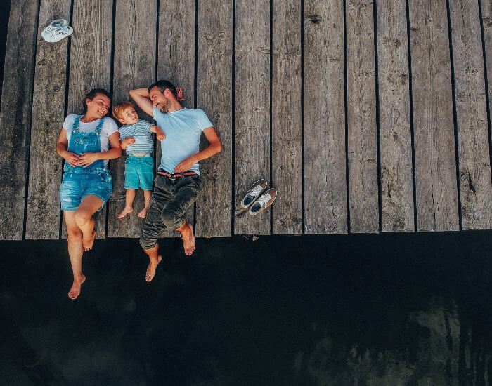 Family laying on dock at lake