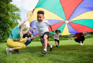 Children playing with play parachute outside in Millersville, MD