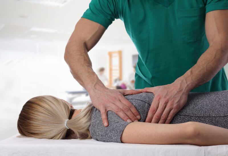 Physical therapist giving woman a back massage