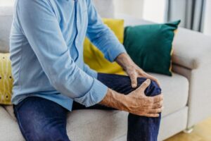 Older man holding his knee that's in pain