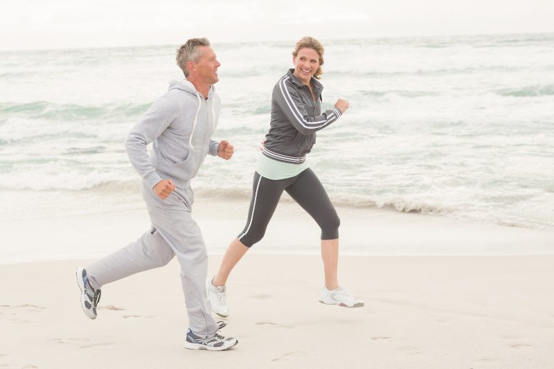 Older couple jogging on the beach
