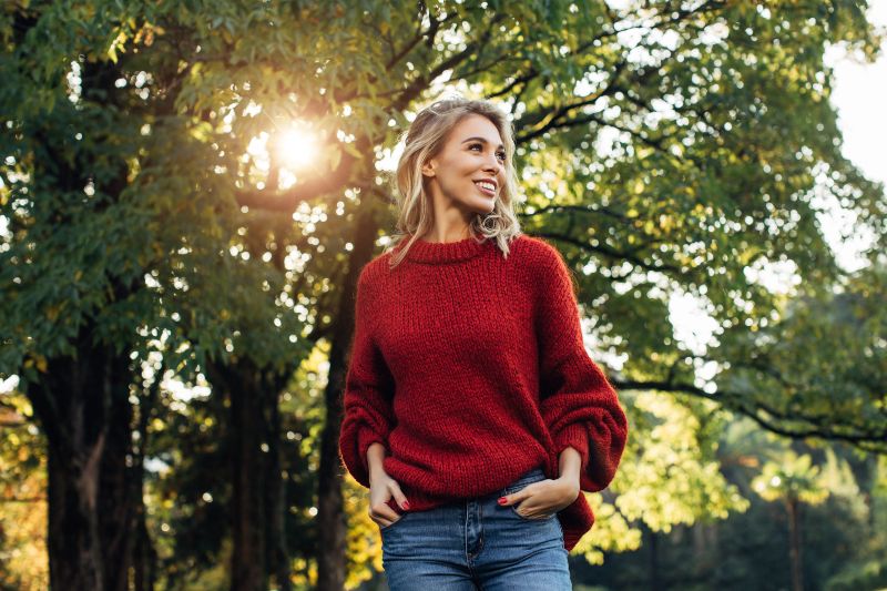 Young blonde woman walking outdoors enjoying the fresh air